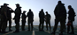 Members of HMCS Iroquois' naval boarding party gather on the flight deck prior to a twilight boarding of a suspect vessel in the Gulf of Oman.<p><p>Credit:  Sgt Frank Hudec/Canadian Forces Combat Camera